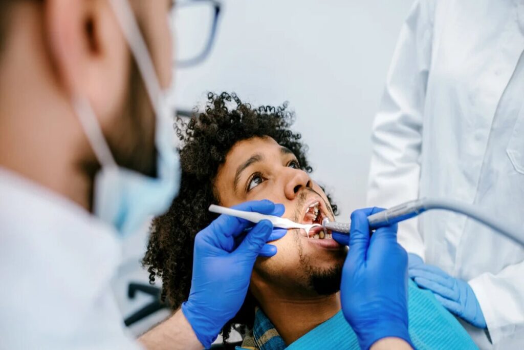 Dentist performing laser gum surgery on a patient to treat receding gums, promoting tissue regeneration and improved oral health.